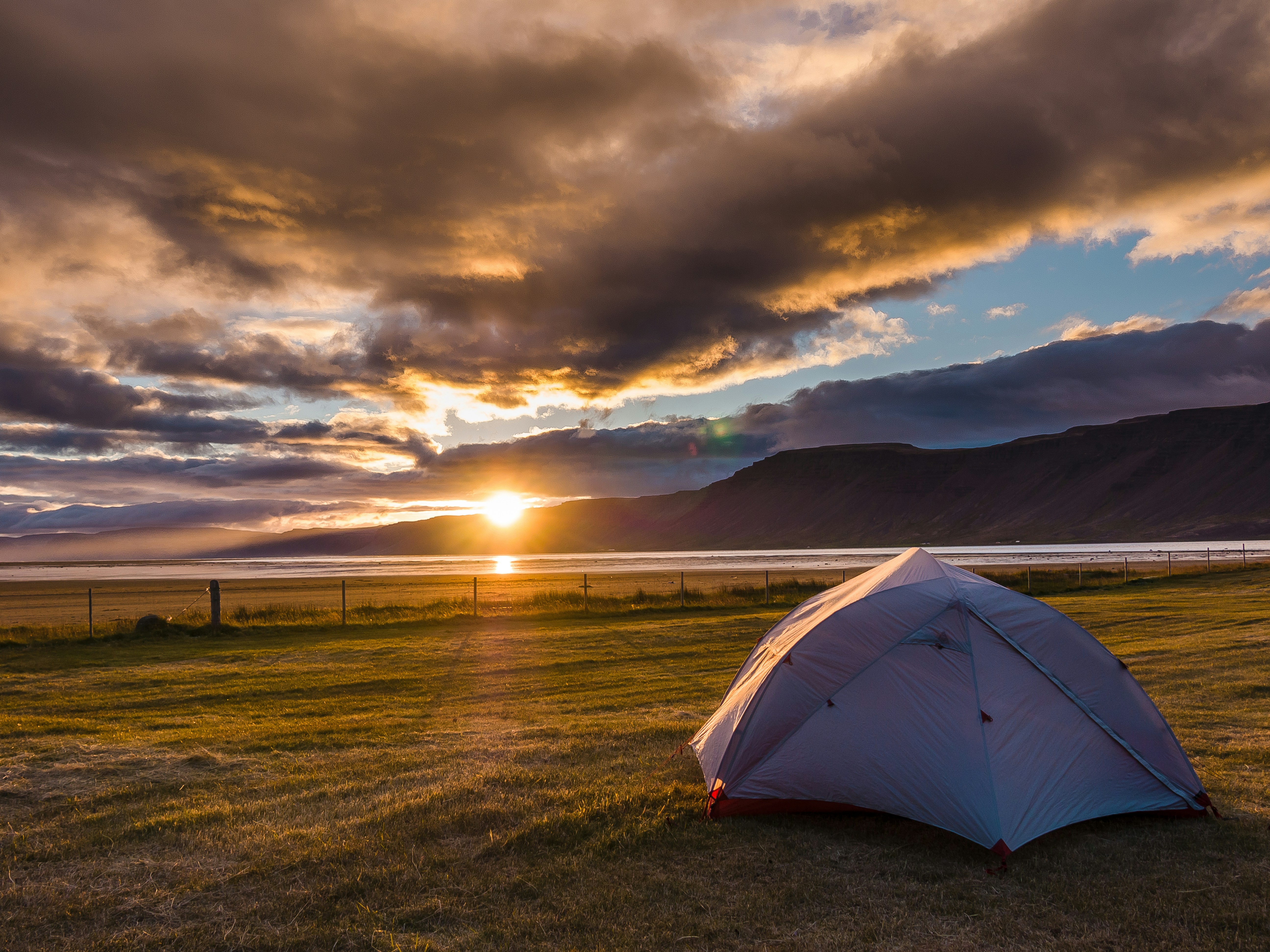 Tent at a campsite with sunset light over Icelandic mountains