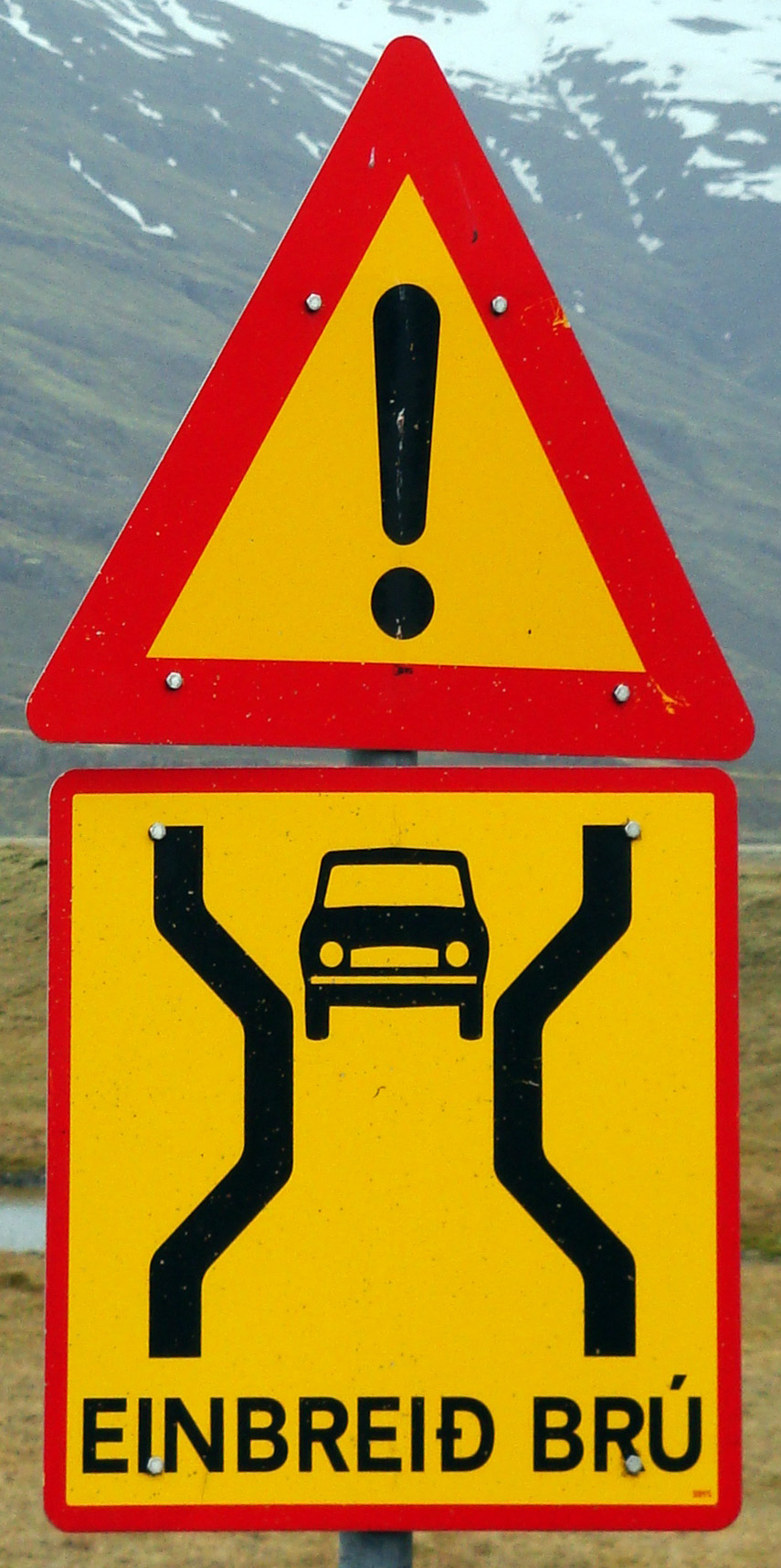 Yellow warning sign reading EINBREIÐ BRÚ — single-lane bridge ahead