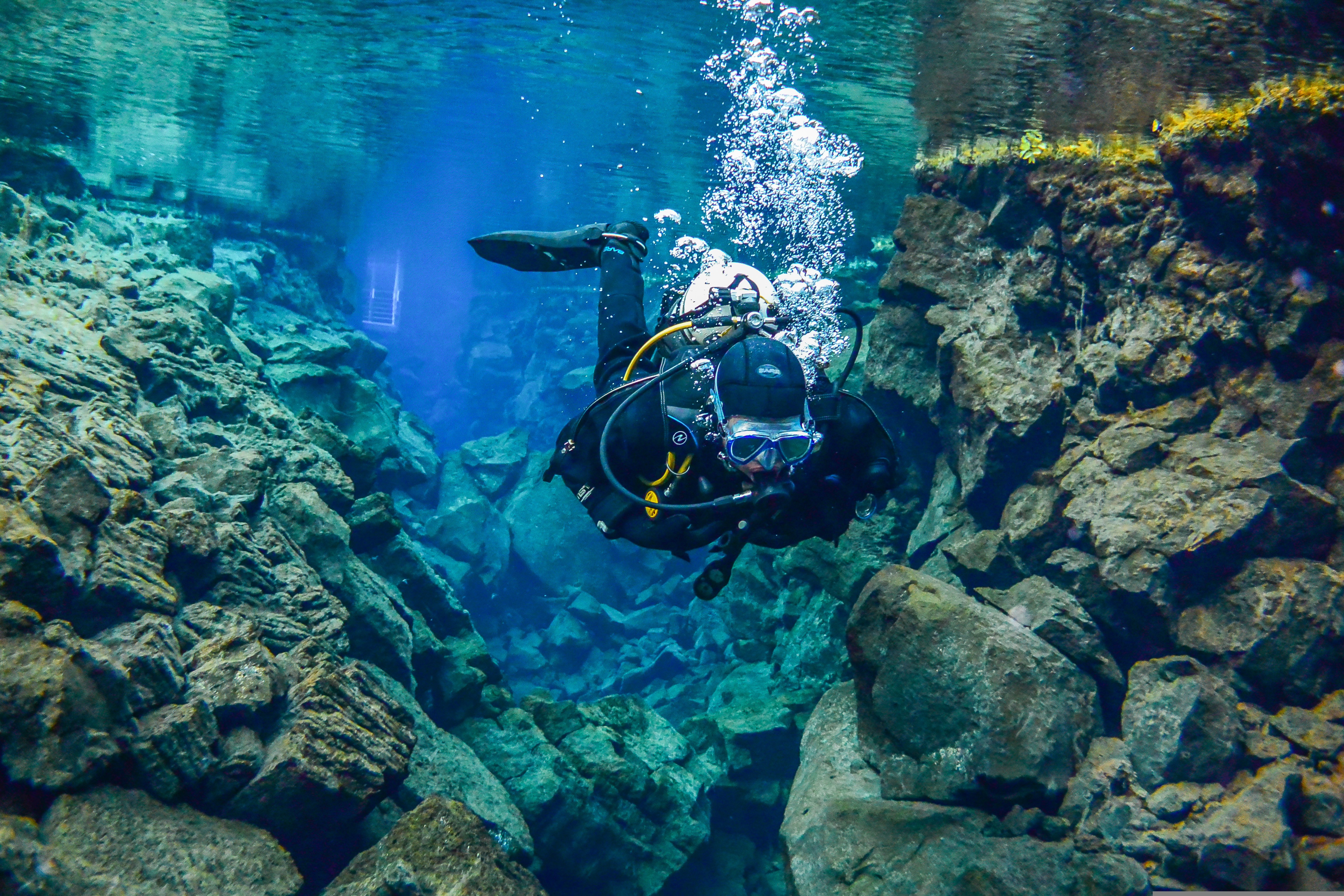 Snorkeler in the clear glacial water of Silfra Fissure between two tectonic plates