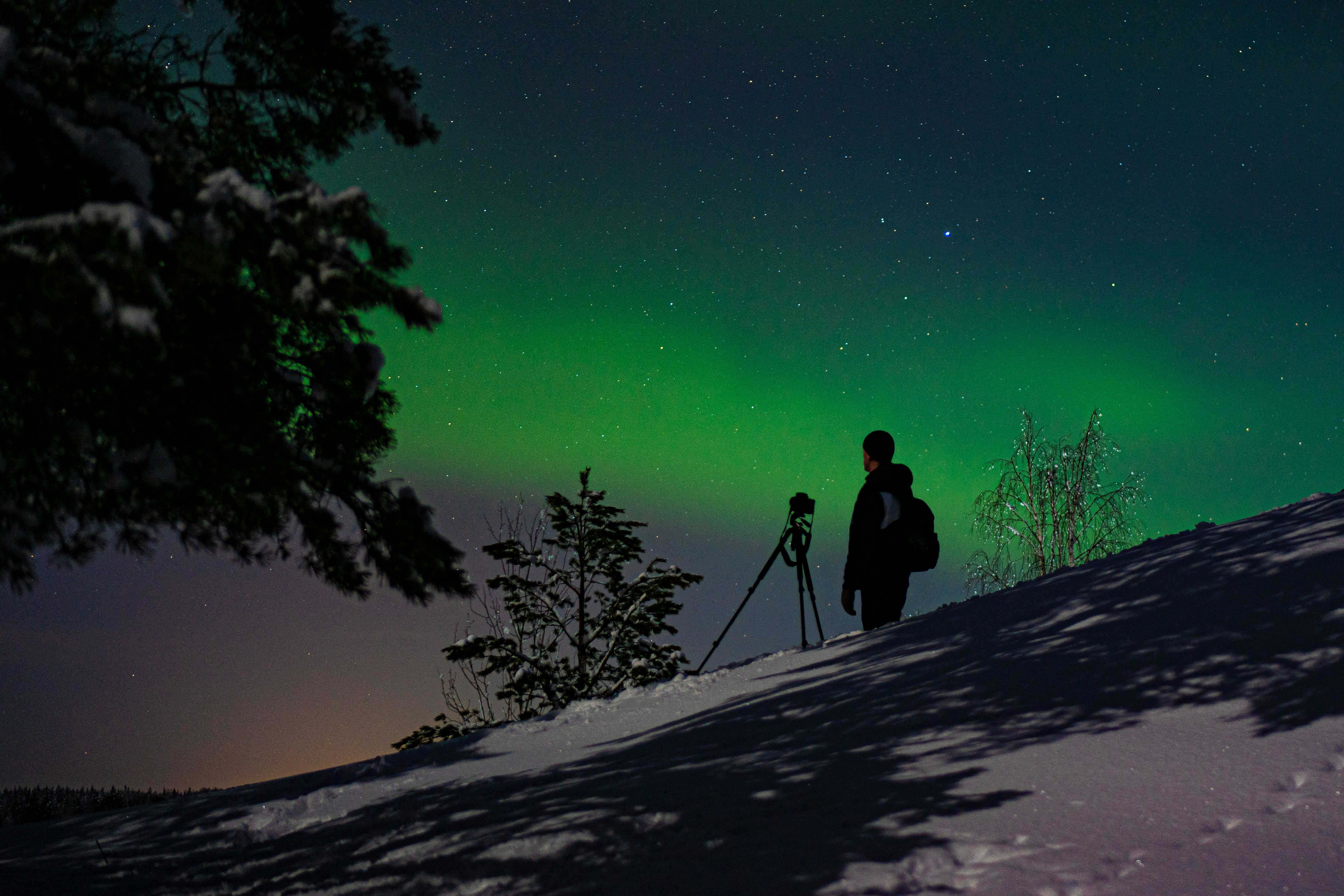 Northern lights photographers standing in snow at night