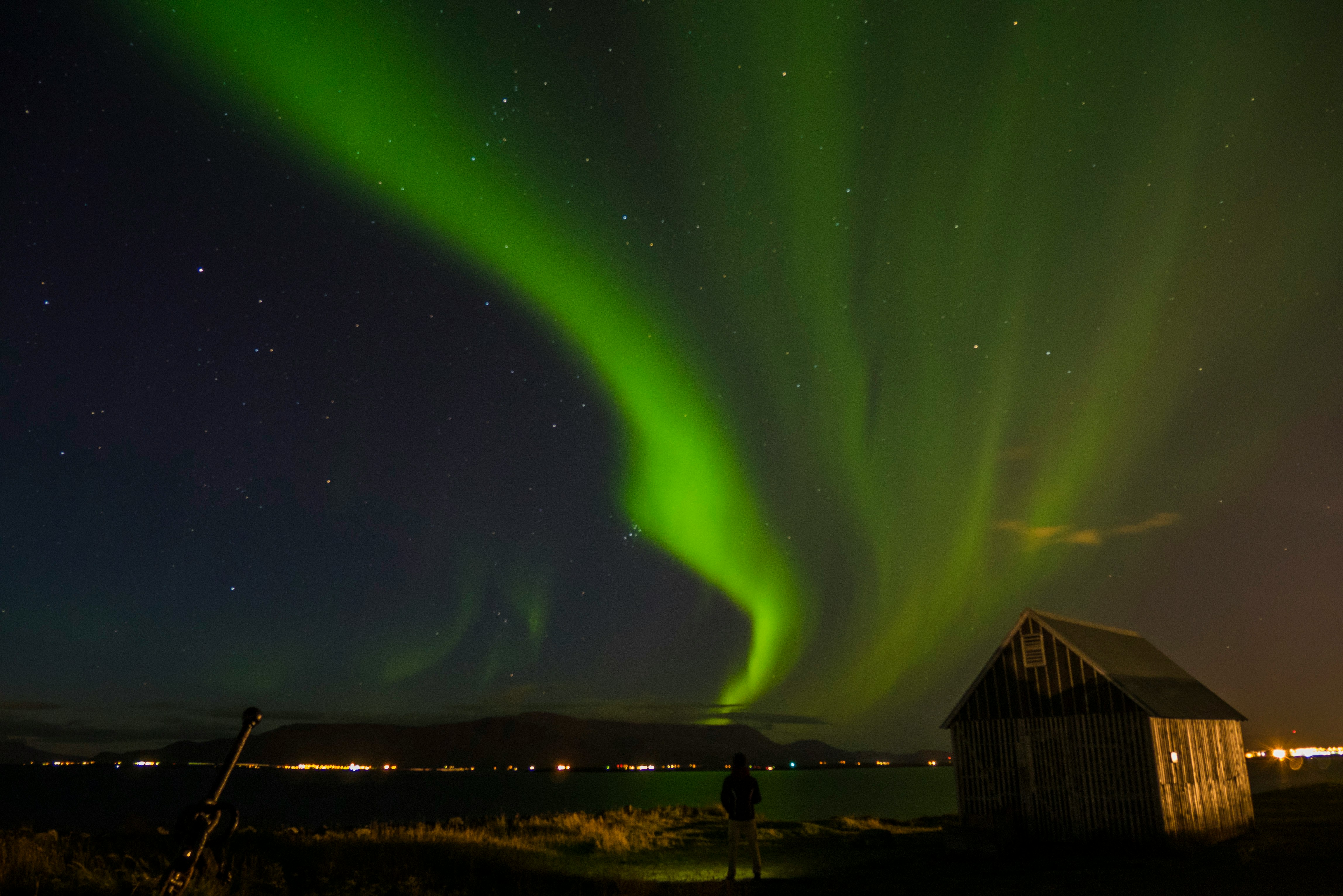 Green northern lights over an old Icelandic farmhouse