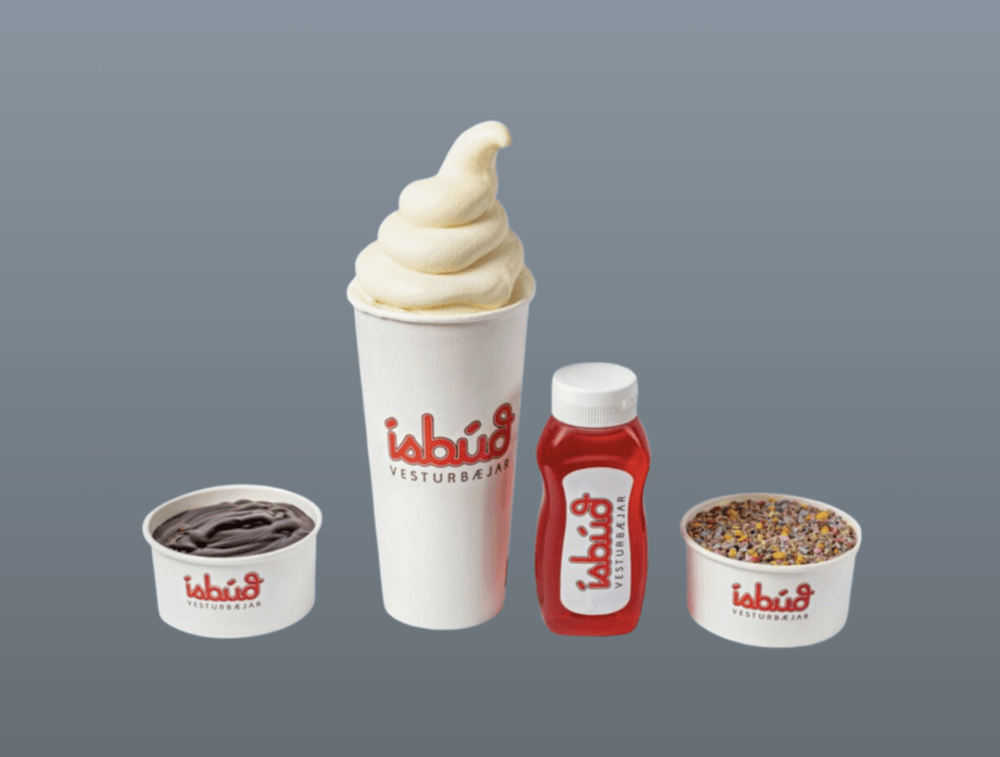 Ísbúð Vesturbæjar soft-serve cone with a cup of chocolate dýfa, sauce and toppings