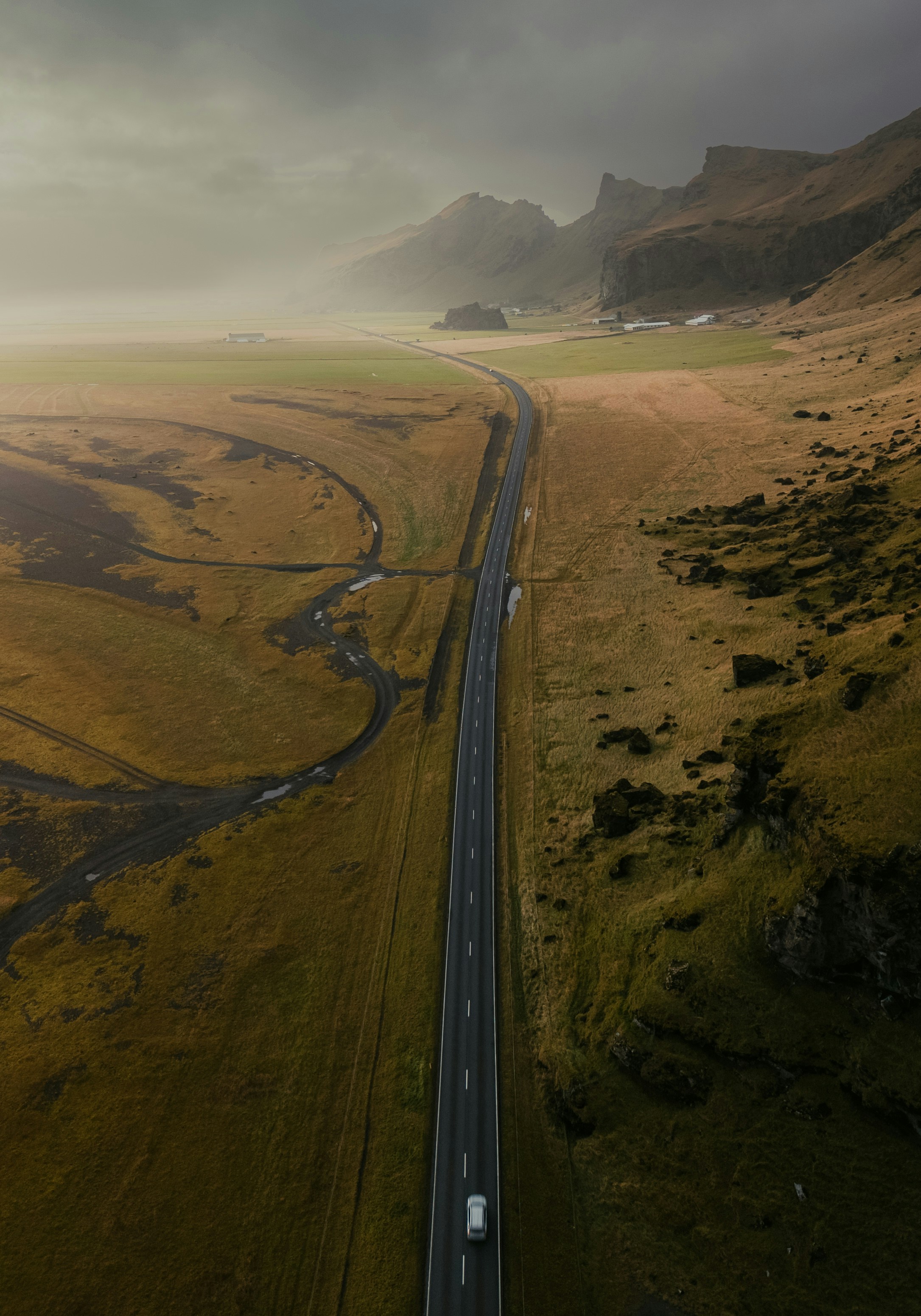 Empty Icelandic coastal road disappearing into low cloud and mist