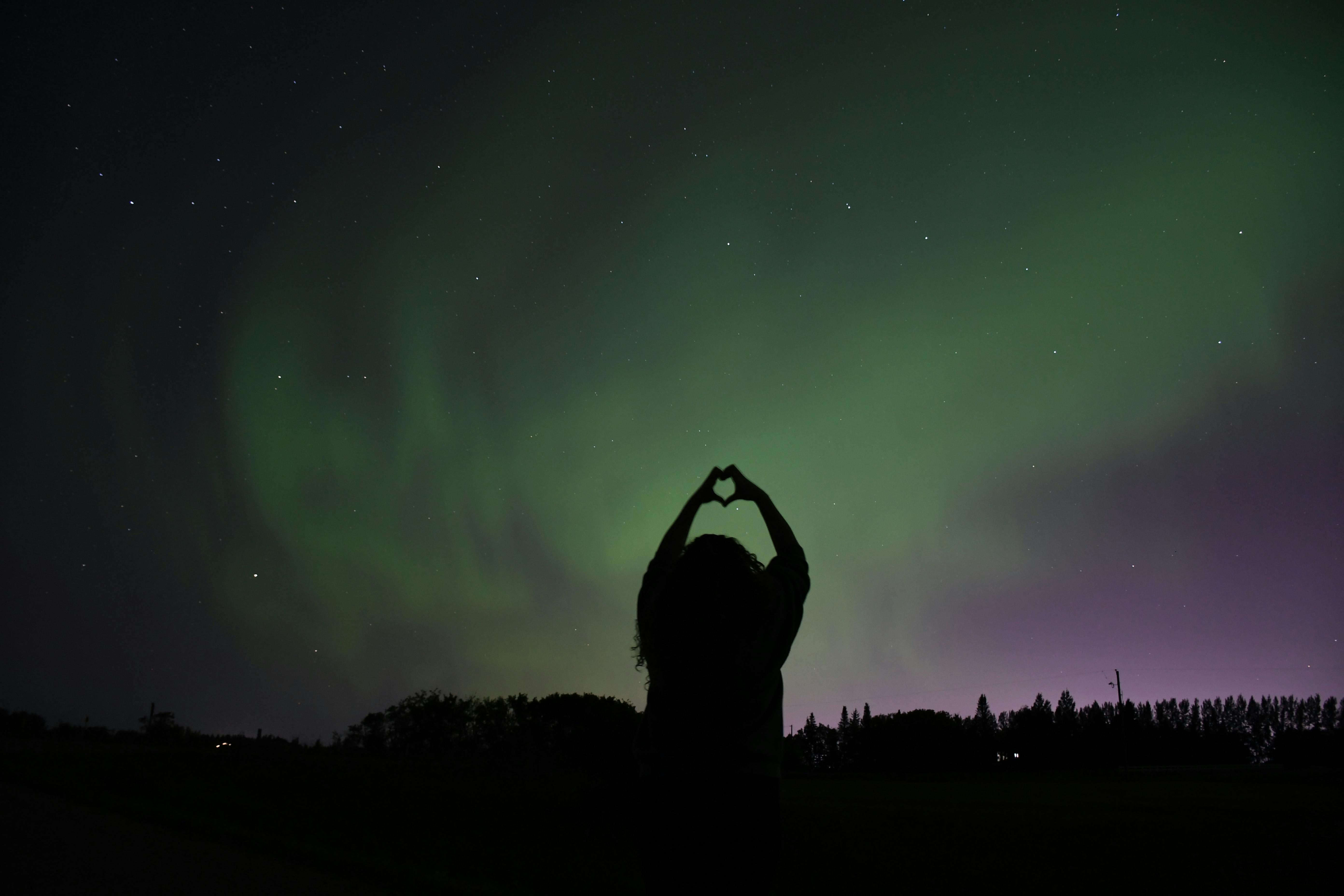 Person photographing northern lights with a phone