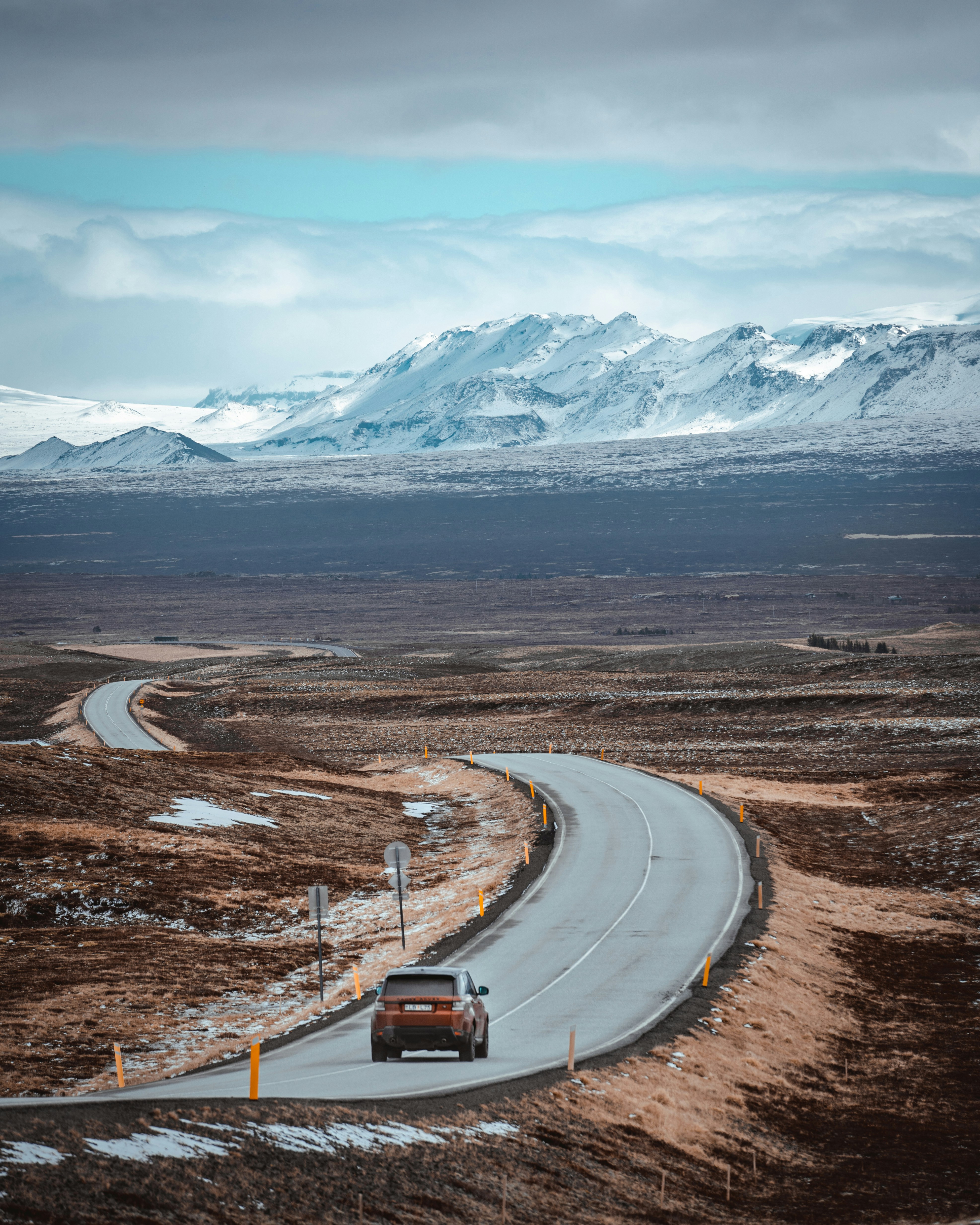 Winding highland road in Iceland with snow-capped mountains
