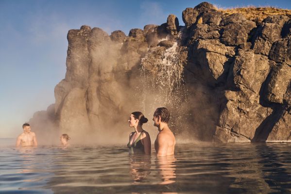 Sky Lagoon geothermal pool with steam rising at dusk