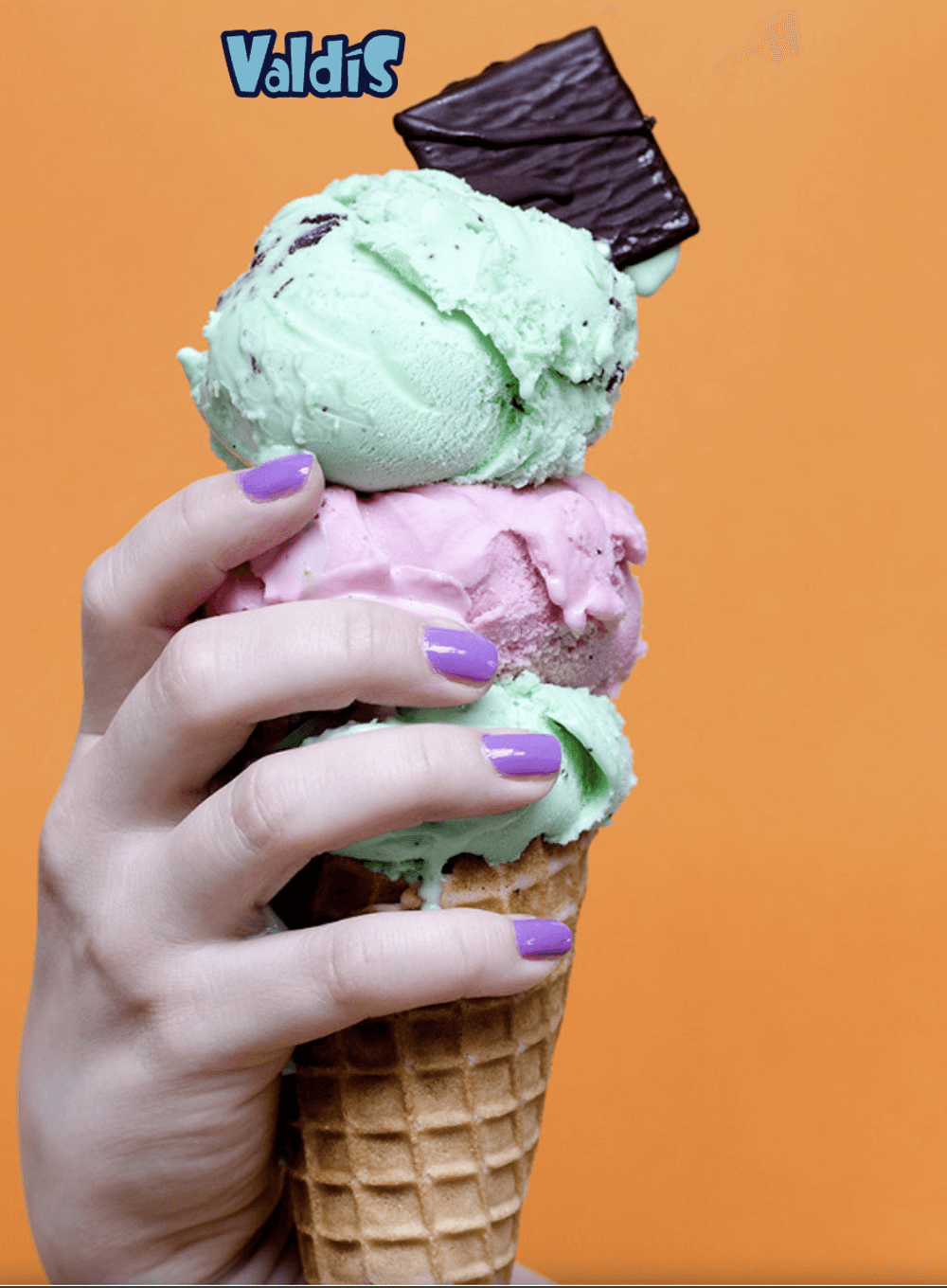A three-scoop Valdís gelato cone with a chocolate wafer