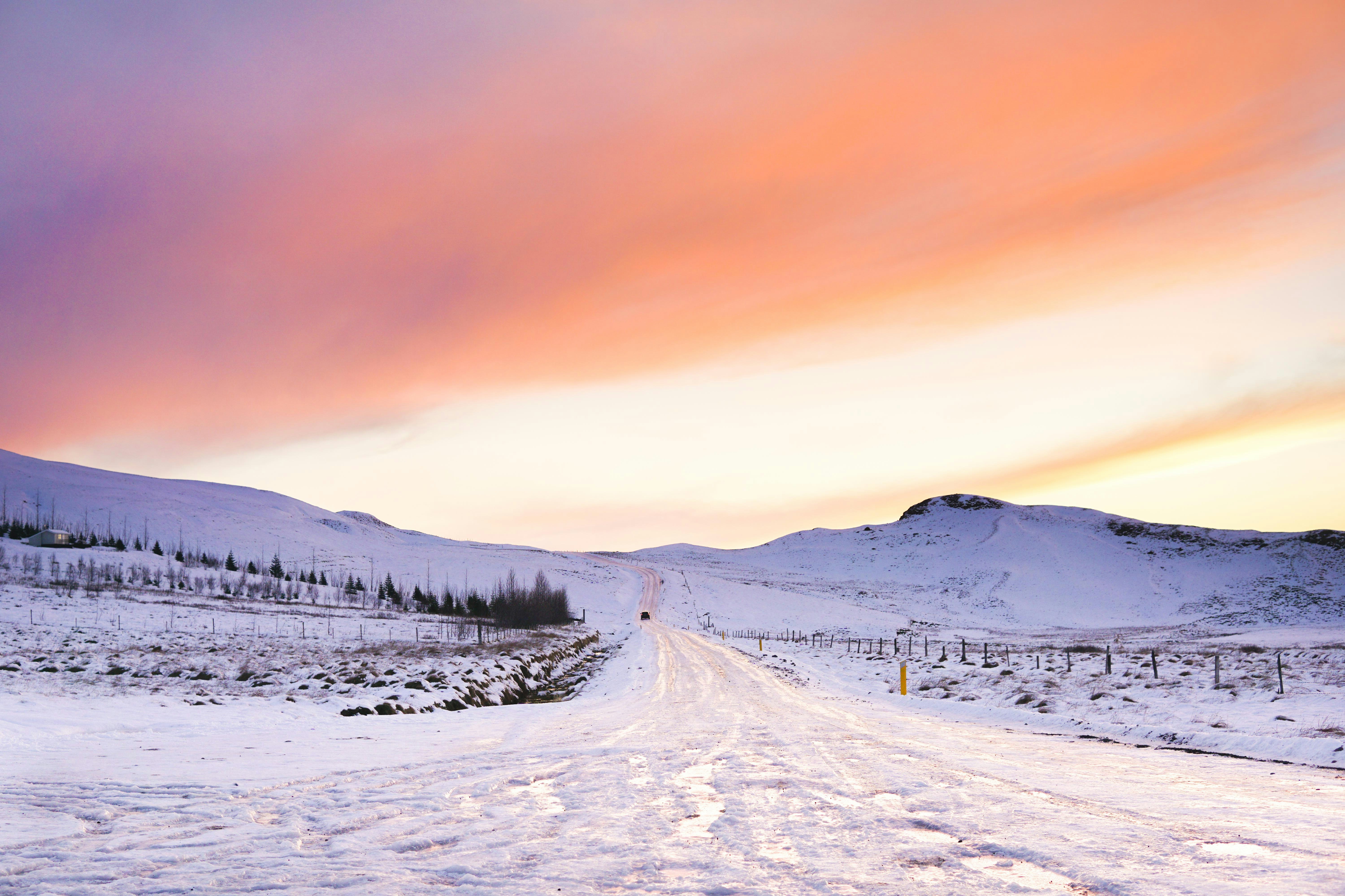 Iceland in winter — snowy road at golden sunset